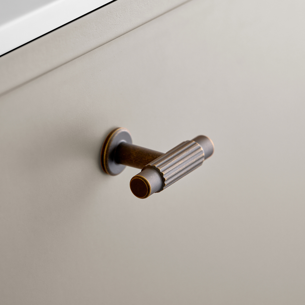Bronze Furnipart Villa T cabinet knob under a white cabinet.