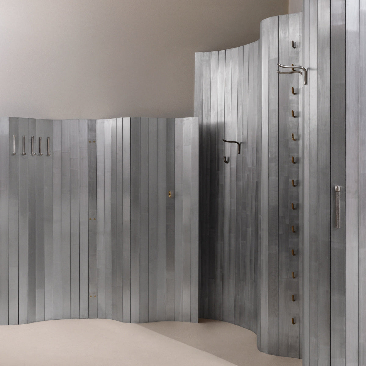 CONTEMPORARY Metallic wardrobe with vertical slats and modern sculptural hooks artfully set up.