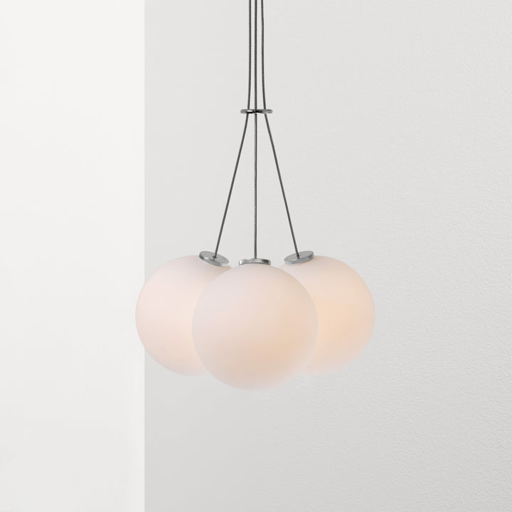 Three Anony Glass 120R Pendant fixtures hanging from a ceiling fixture.