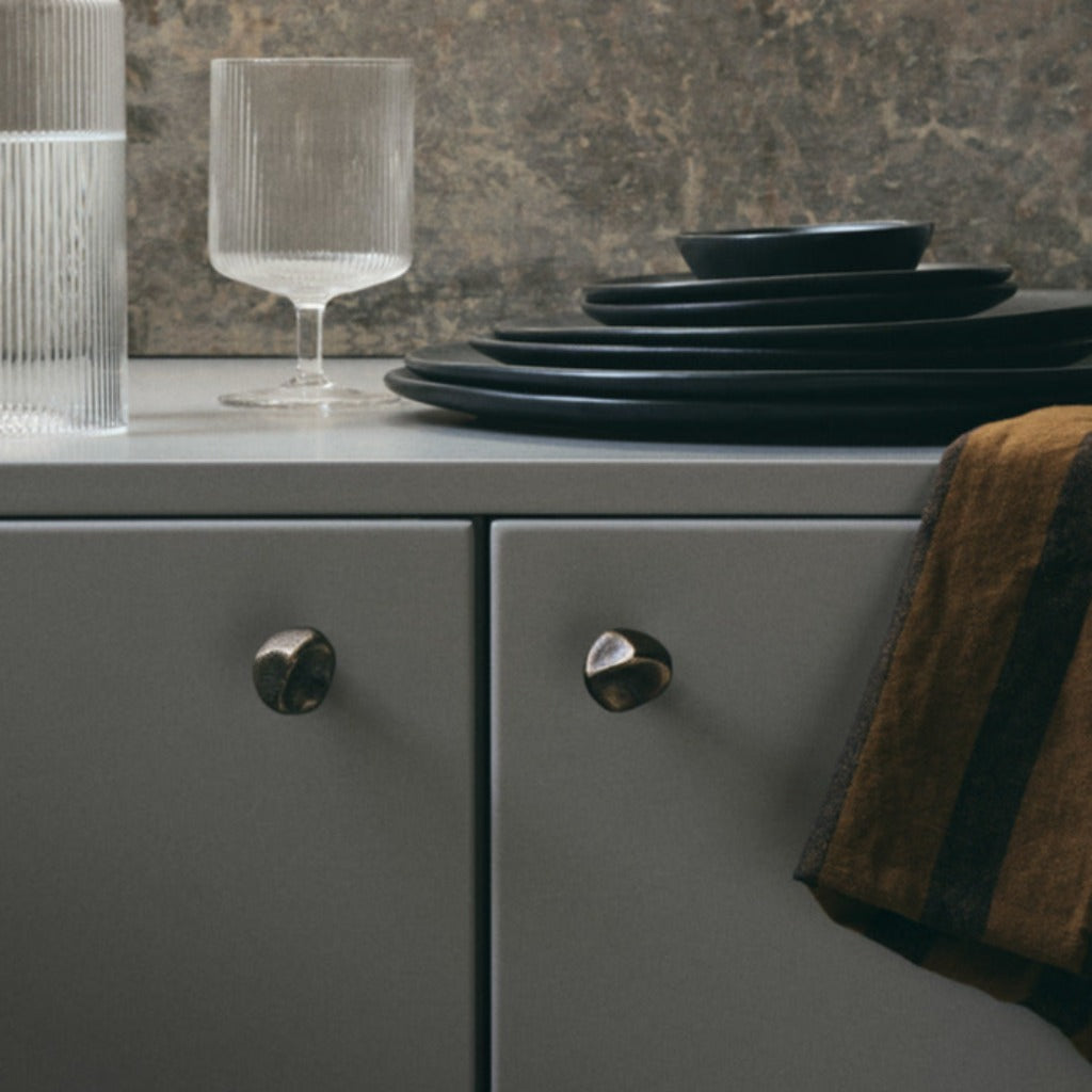 Gravel hook in antique brass on grey kitchen cabinet doors