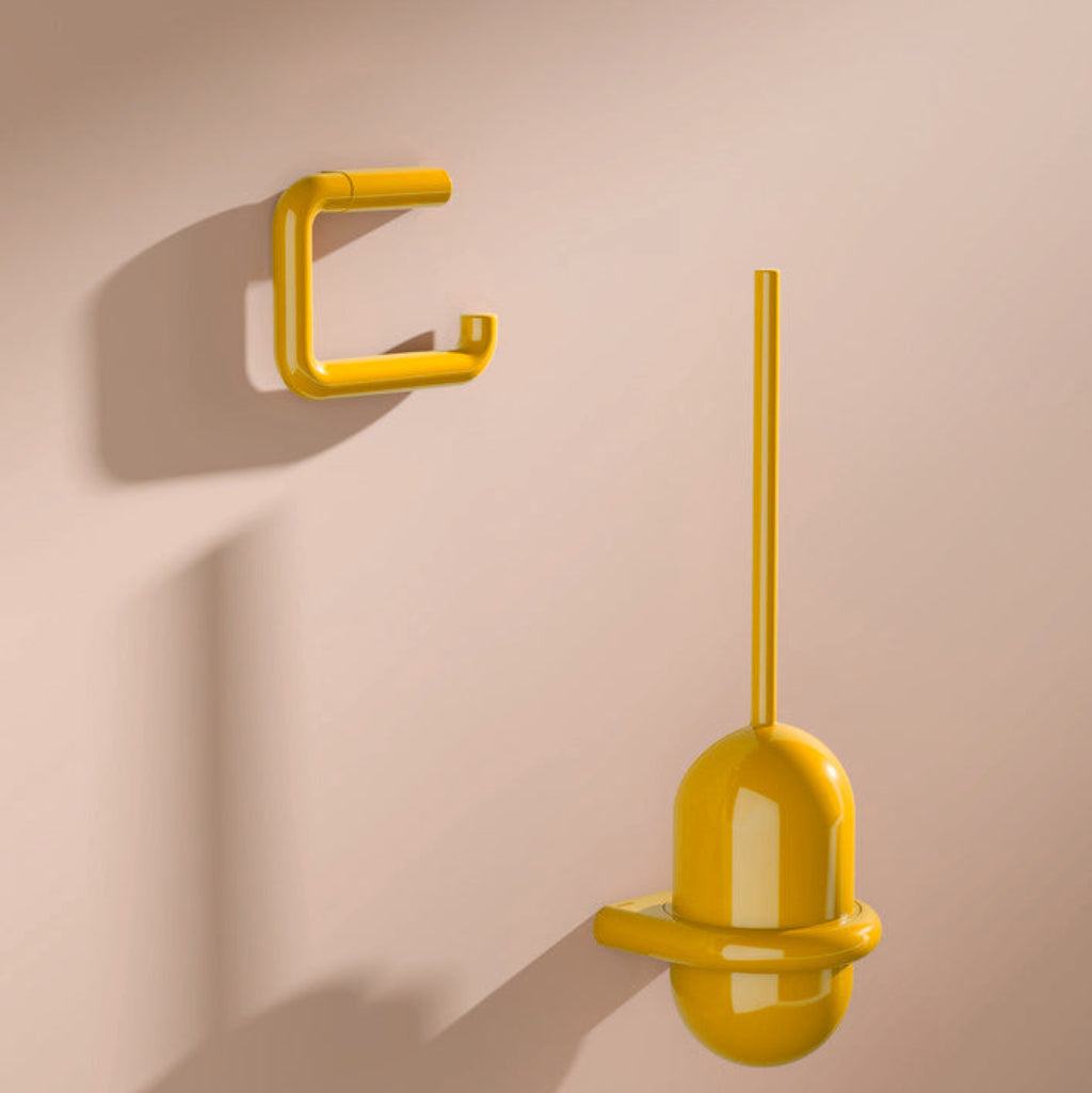 Yellow Hewi 477 toilet brush unit and hook on a peach wall.