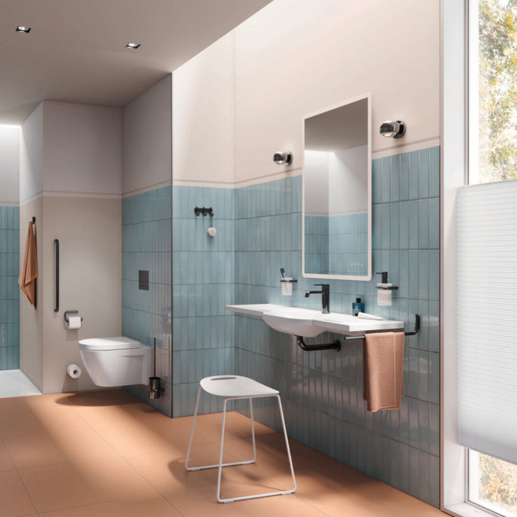 A blue-tiled bathroom with a wall basin and Hewi 477 fittings.
