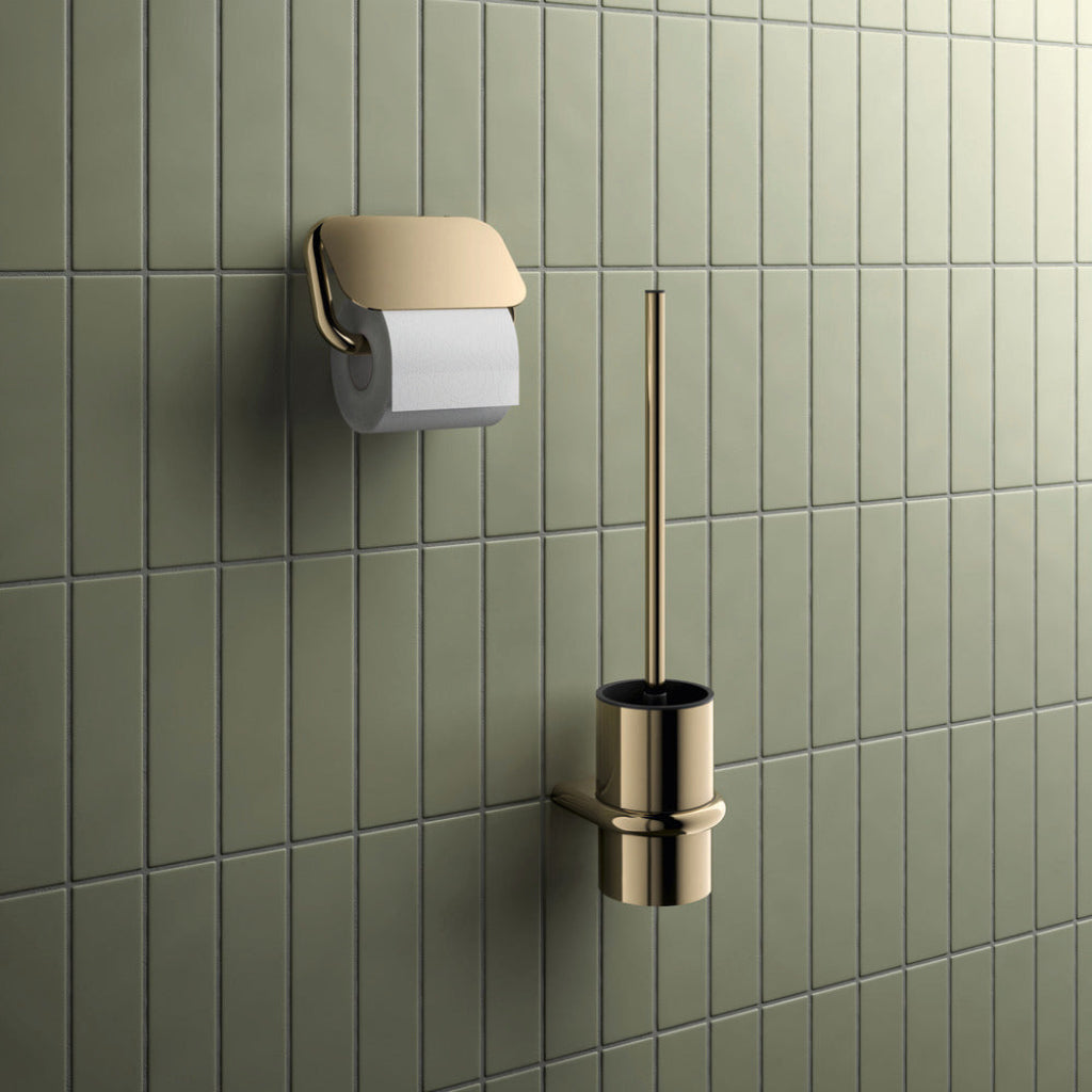 Bronze Hewi 480 toilet roll holder and toilet brush on a green tiled wall.