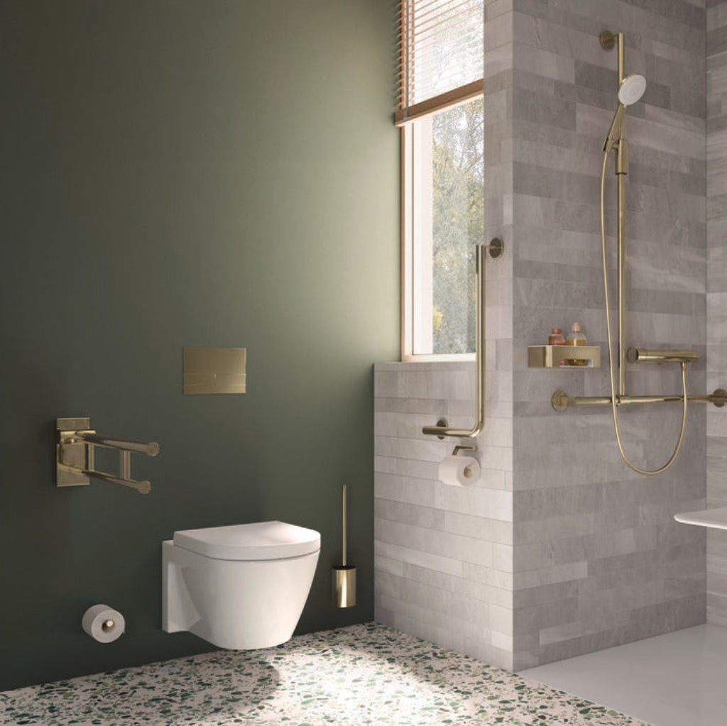 A green bathroom with brass Hewi fixtures.