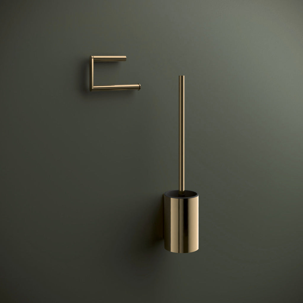 Brass Hewi 900 toilet roll holder and toilet brush on a green wall.