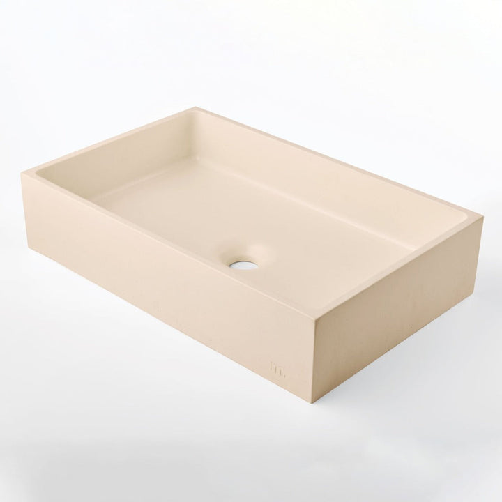 A mudd. concrete Jeker Basin sink sitting on top of a mudd. concrete white counter.
