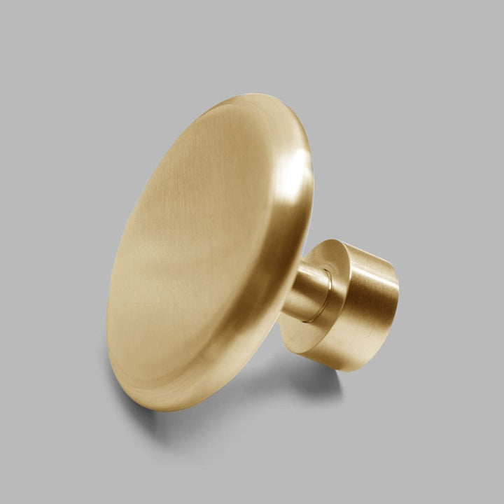 A dline knud coat hook in satin brass.