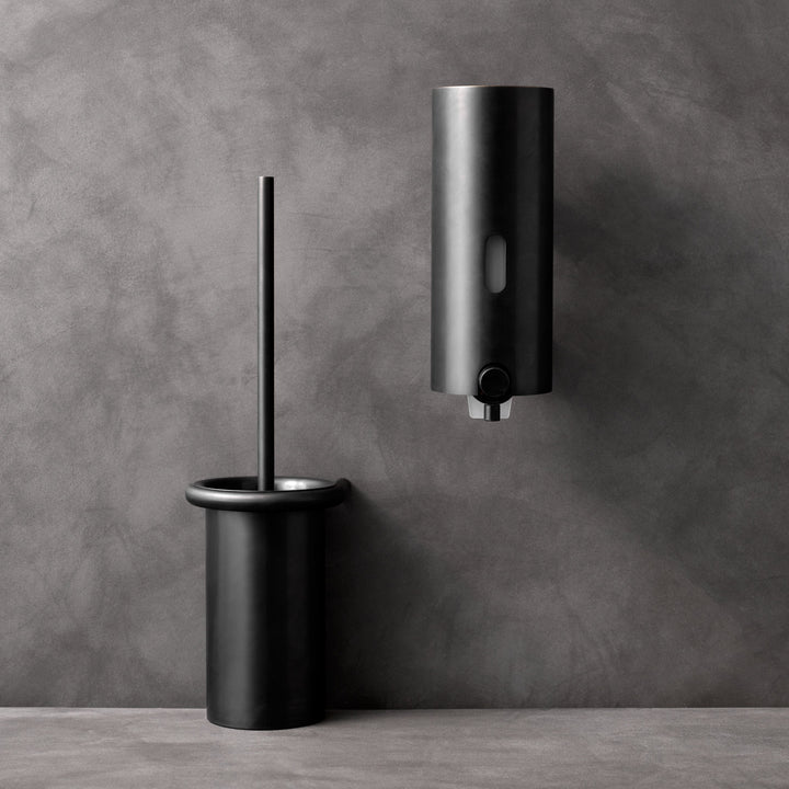 a Knud Soap Dispenser by d line and a toilet paper dispenser.