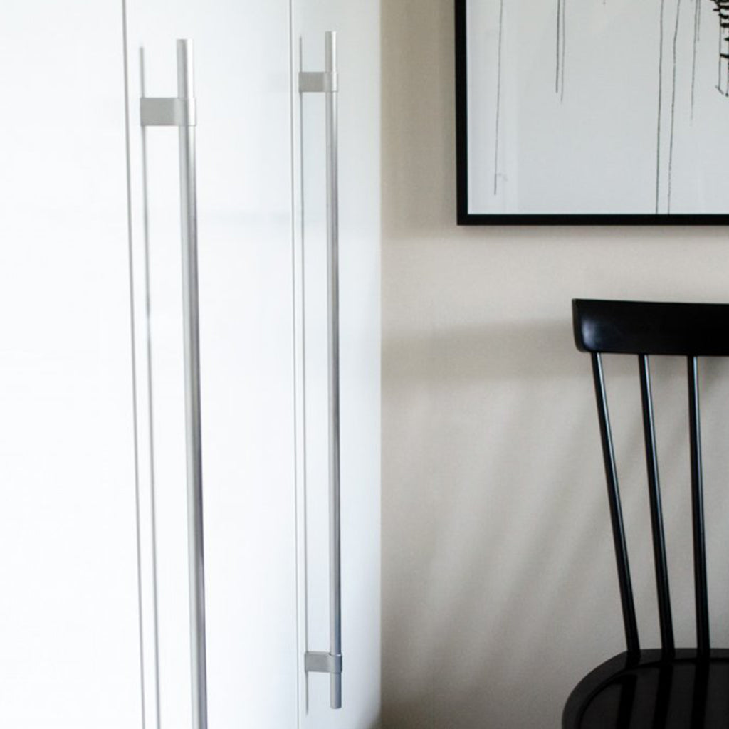 A black Line Big Handle chair sitting in front of a white Baccman Berglund refrigerator.