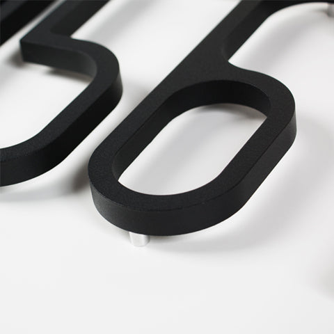 A close up of a LIXHT Aluminum Number Small on a white surface.