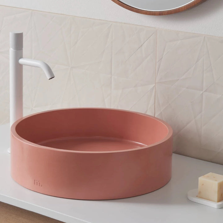 A Mudd. Concrete Odet Basin LG with a soap dispenser next to it.