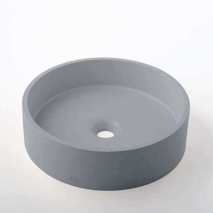 A mudd. concrete Odet Basin LG sink on a white surface.