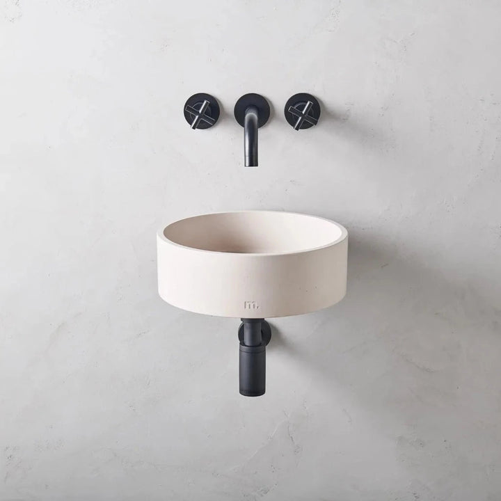 Circular wash basin with white finish affixed to wall