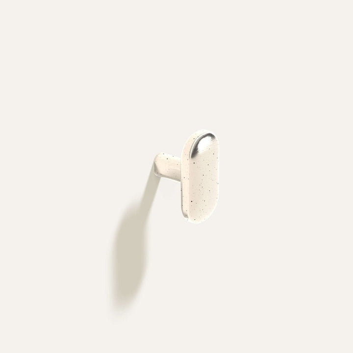 Oval Knob or Hook in polished white bronze installed on a white wall.