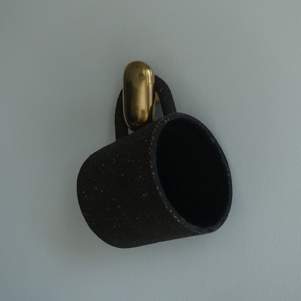 Matte black Maha Alavi Oval hook on a wall.