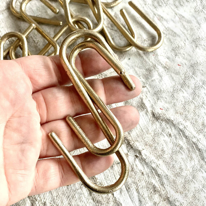 a person holding a Shayne Fox Pyra S Hook in their hand.