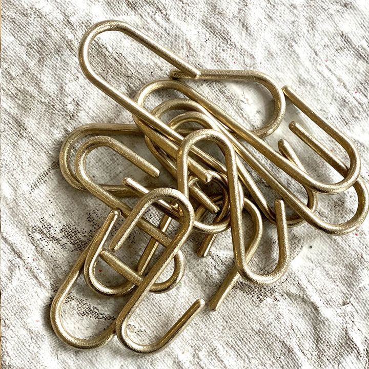 A pile of Pyra S Hooks by Shayne Fox sitting on top of a table.