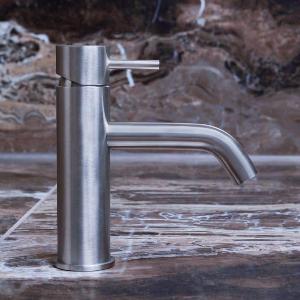 qtoo faucet by d line crafted from AISI 316 marine grade stainless steel shown here in satin stainless steel mounted in bathroom on marble counter