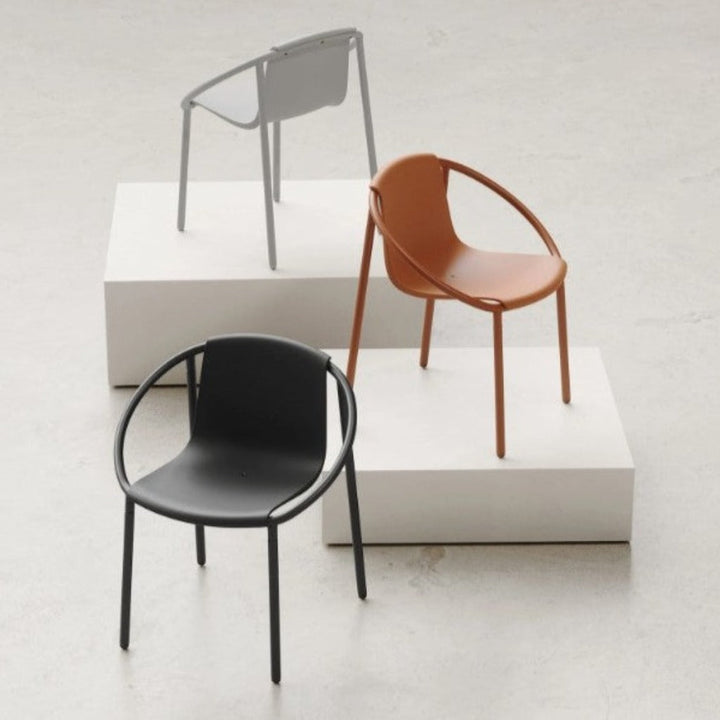 Three Umbra Ringo Chairs sitting on top of a white platform.