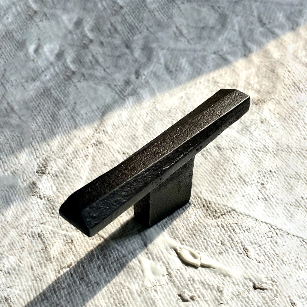 a Shayne Fox Skew Knob/Hook sitting on top of a white blanket.