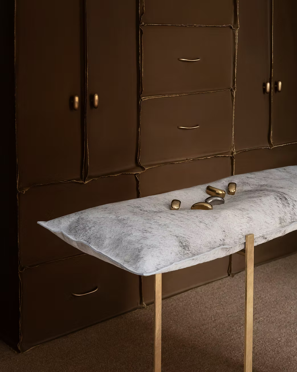 Jewel Like brass cabinet hardware displayed on a pillow