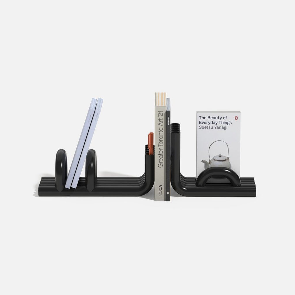 Black TUBE Bookends photographed on a white background with a collection of books in between on a white background