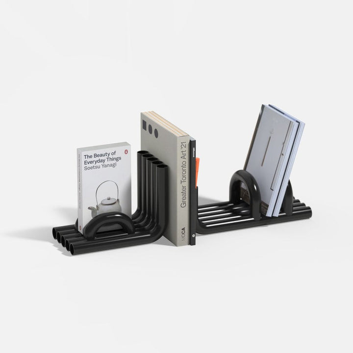 Black TUBE Bookends photographed on a white background with a collection of books in between