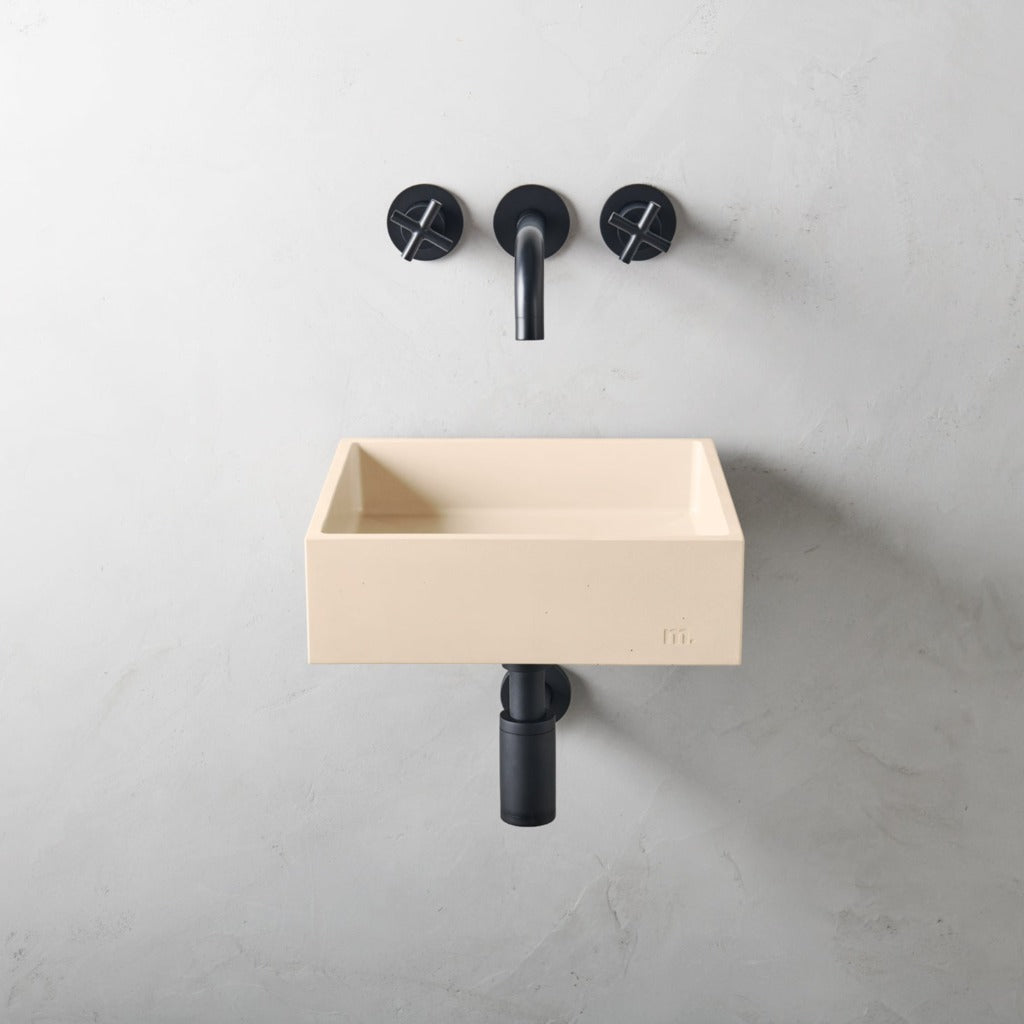 A mudd. concrete Yarra Basin SM Affix with a black faucet and a white wall.