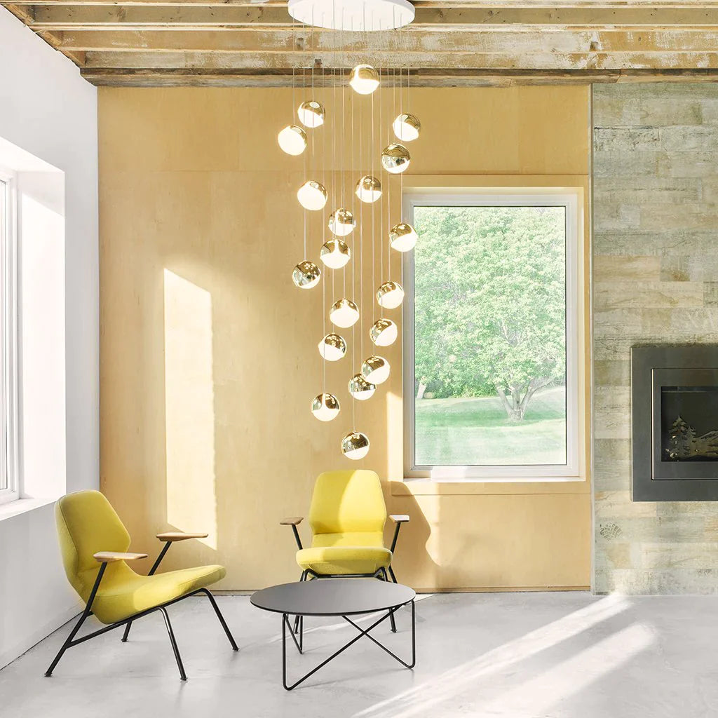 A beautiful modern cascading chandelier of round spherical lights with brass casing. 