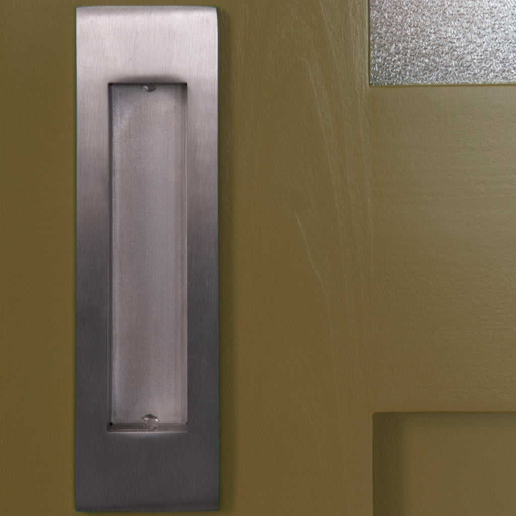 A close up of a 1925Workbench Flush Door Pull on a door.