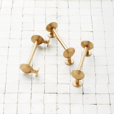 Spul Pull in satin brass on organic marble tile backdrop