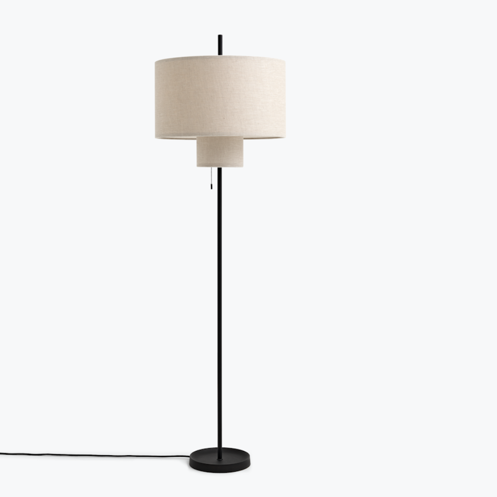 A round, tiered floor lamp with a thin black base