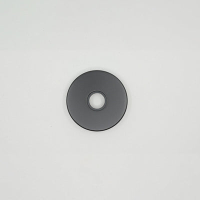 a black disc sitting on top of a white surface.