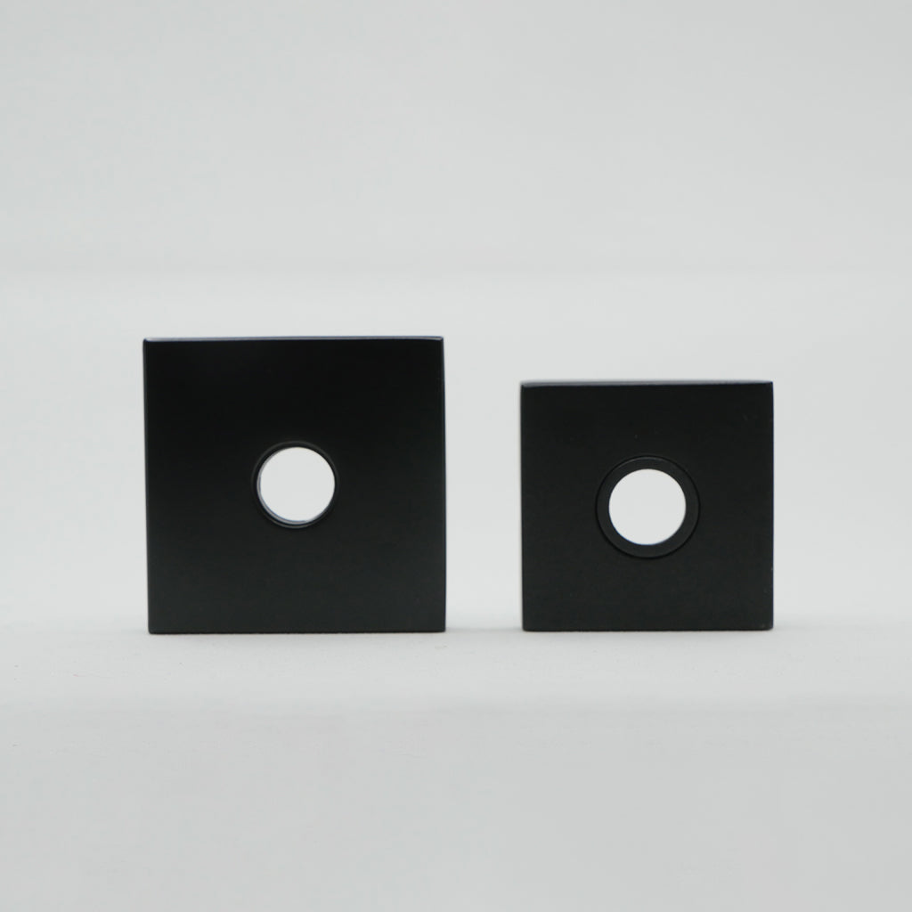 a pair of black square speakers sitting on top of each other.