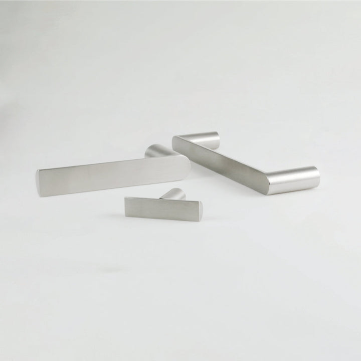 A couple of Formani ARC Lever Handles sitting on top of a white table.