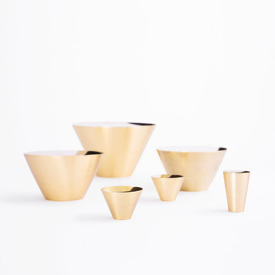 A group of Maison Vervloet's Audrey Knob 30 gold bowls sitting next to each other.