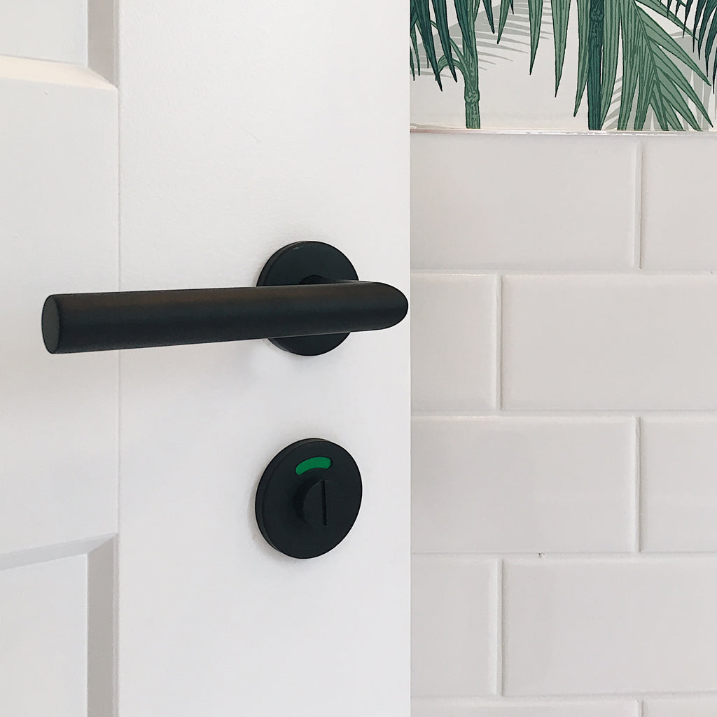 A black handle on a white Formani BASICS LBII-19 Door Lever.