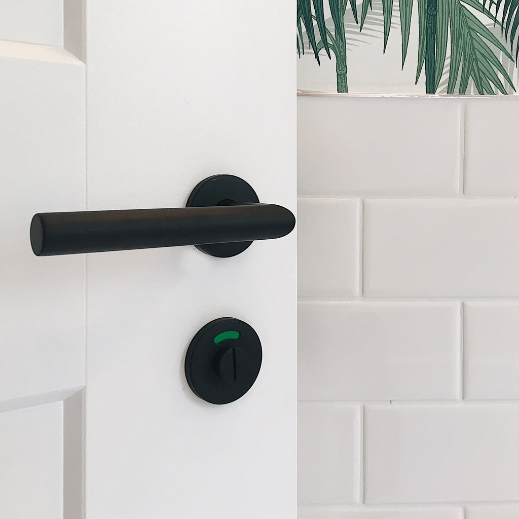 A black handle on a white Formani BASICS LBII-19 Door Lever.