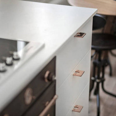 Little copper handles on modern kitchen cabinetry.