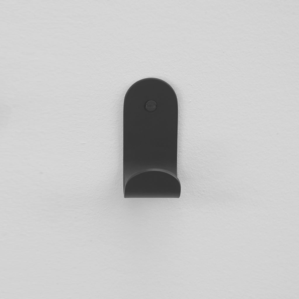 The Bende Hook 1 from CSSN in matte black with flat head screw installed on white wall