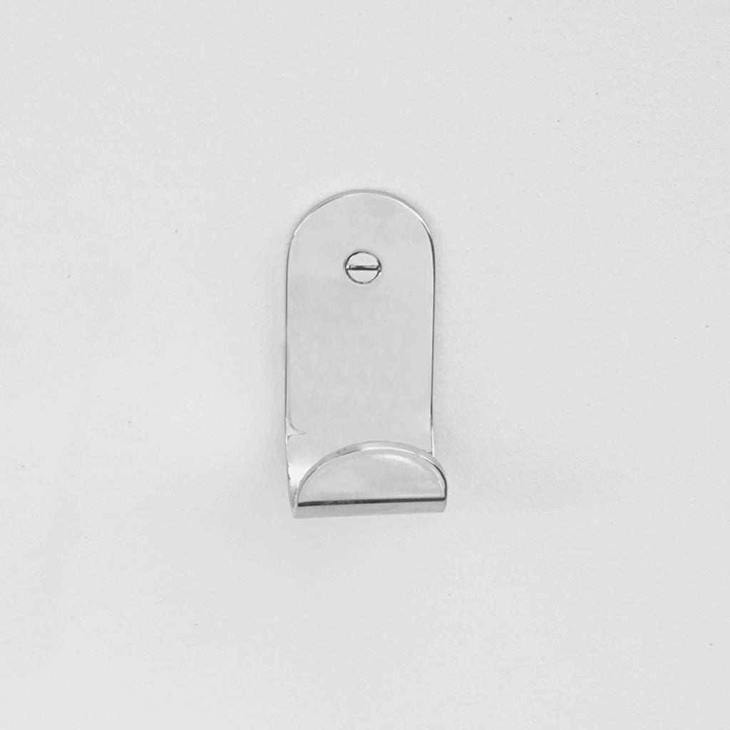 The Bende Hook 1 from CSSN in polished mirrored Stainless Steel with flat head screw installed on white wall