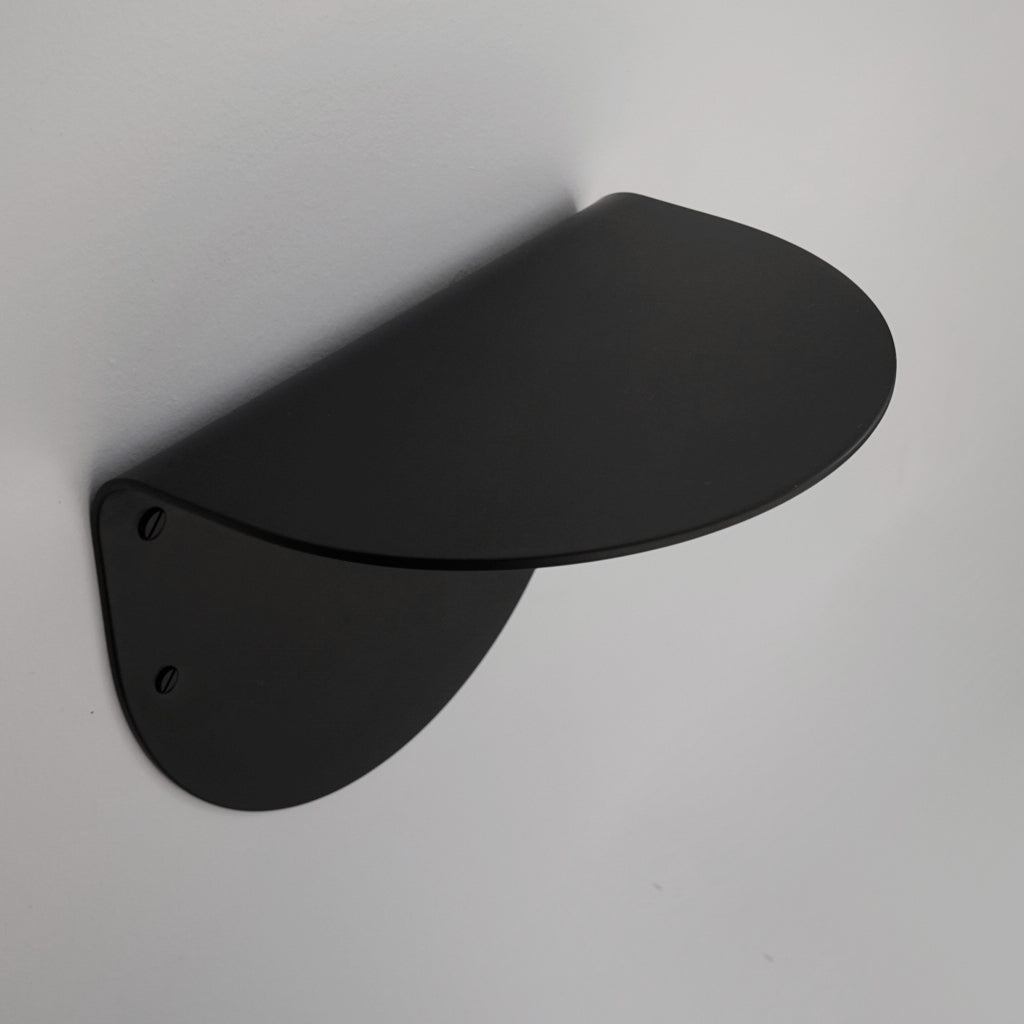 A black BENDE Shelf Ledge mounted to the side of a wall by CSSN.