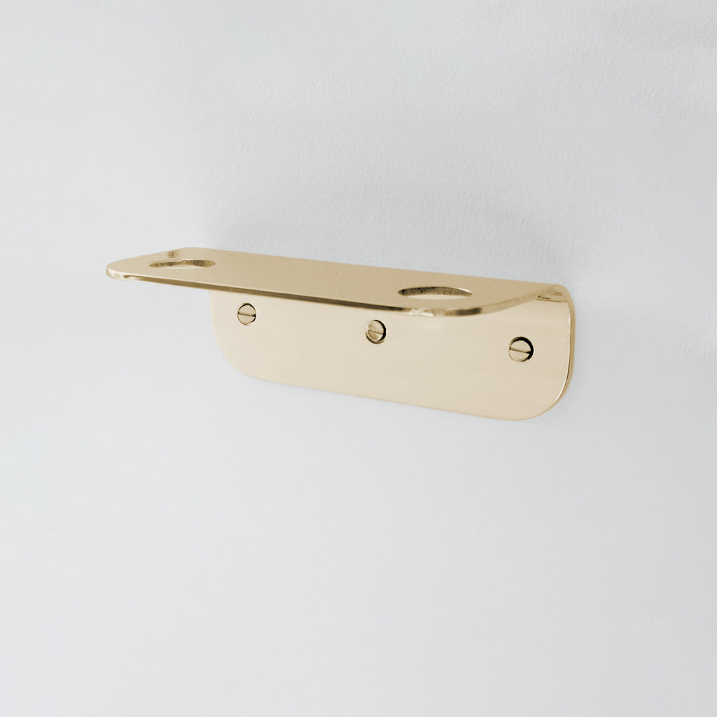 Bende Double Soap Holder in Mirrored Brass mounted on white wall with 3 slot head screws