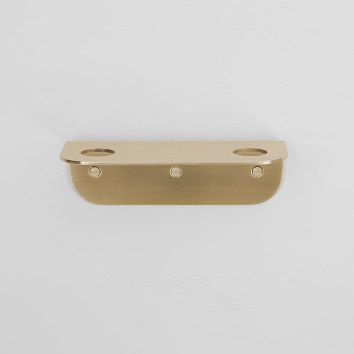 Bende Double Soap Holder in satin brass mounted on white wall with 3 slot head screws