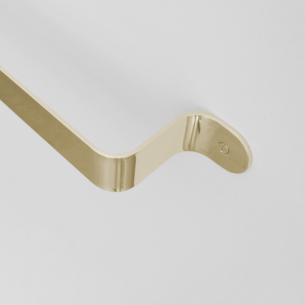 Bende Polished Brass Towel Bar Installed on white wall detail of angle