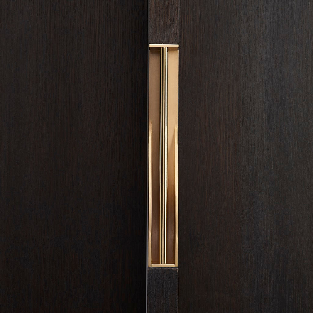 Elegant brass dressing handle on a dark wood door from the front. Beautifully and functionally designed.