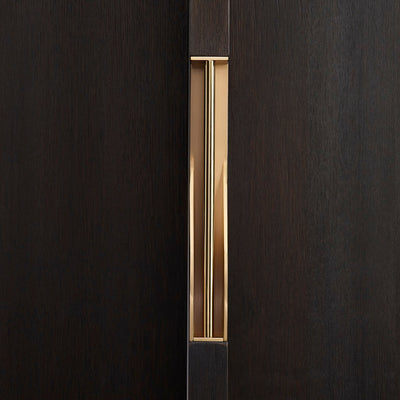 Elegant brass dressing handle on a dark wood door from the front. Beautifully and functionally designed.