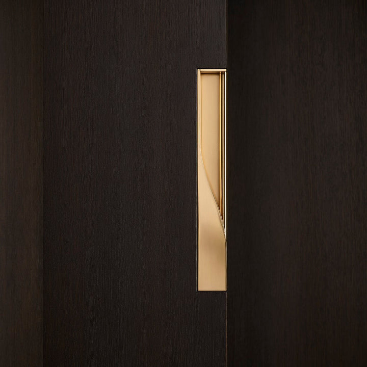 Elegant brass dressing handle on a dark wood door from the side. Beautifully and functionally designed.