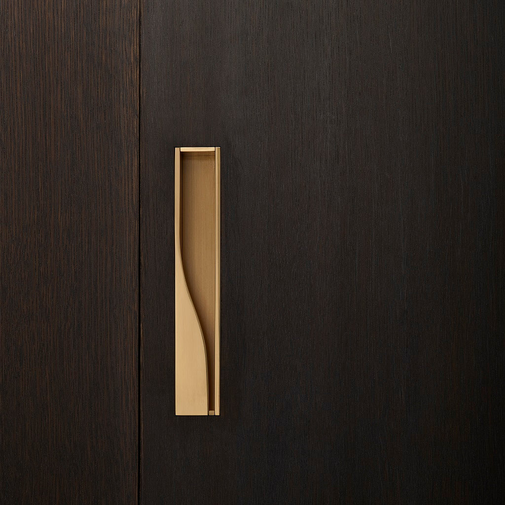 Elegant brass sliding door handle on dark wood from the front. Beautifully and functionally designed.