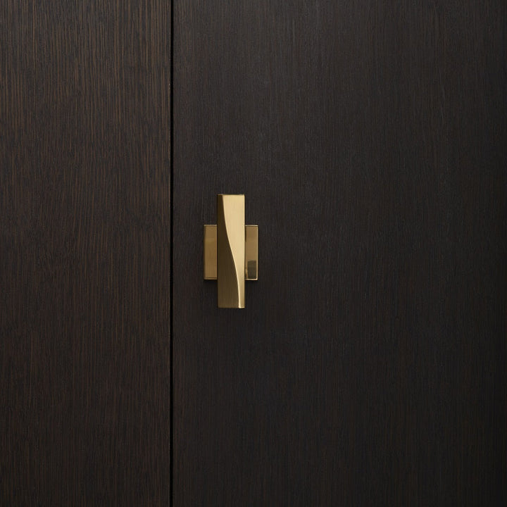 Elegant brass door knob with square rose on a dark wood door. Beautifully and functionally designed.